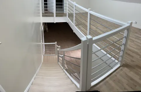 Escalier blanc avec palier et garde-corps à barreaux