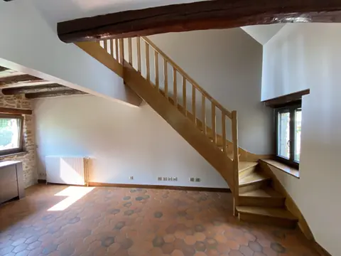 Escalier en bois dans une maison ancienne aux poutres apparentes