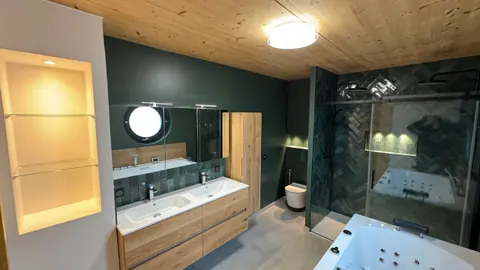 Salle de bains vert sapin avec double vasque et plafond en bois
